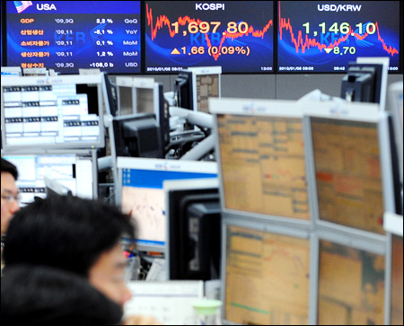 Currency dealers monitor computer screens as the ... - The Korea Times