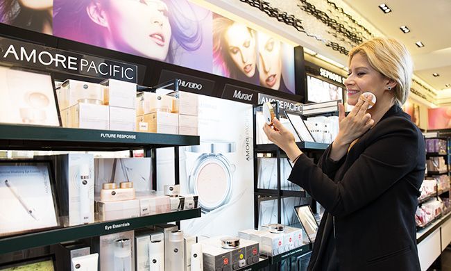 A customer applying Amorepacific cushion foundation at a Sephora store in New York