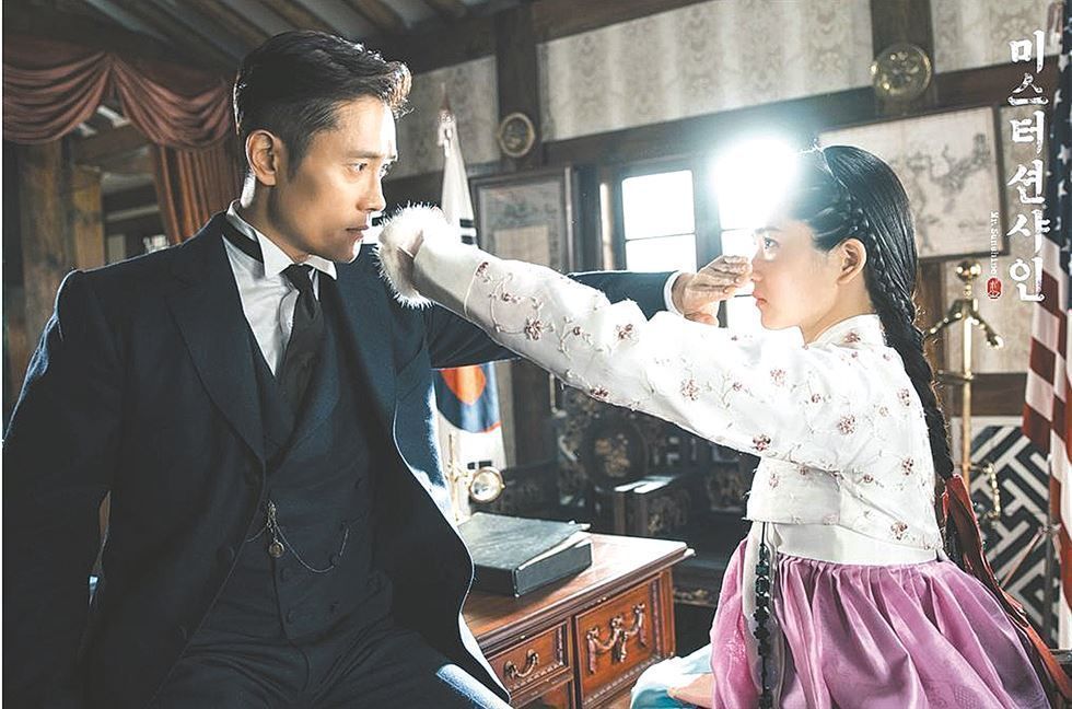 A cinematic late-Joseon era scene from tvN drama Mr Sunshine featuring Lee Byung-hun in period costume against a war-torn historical backdrop
