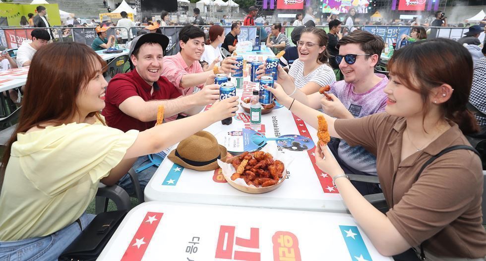 Visitors toast with beer at the opening night of the Daegu Chimac Festival at Duryu Park in Daegu, July 2019