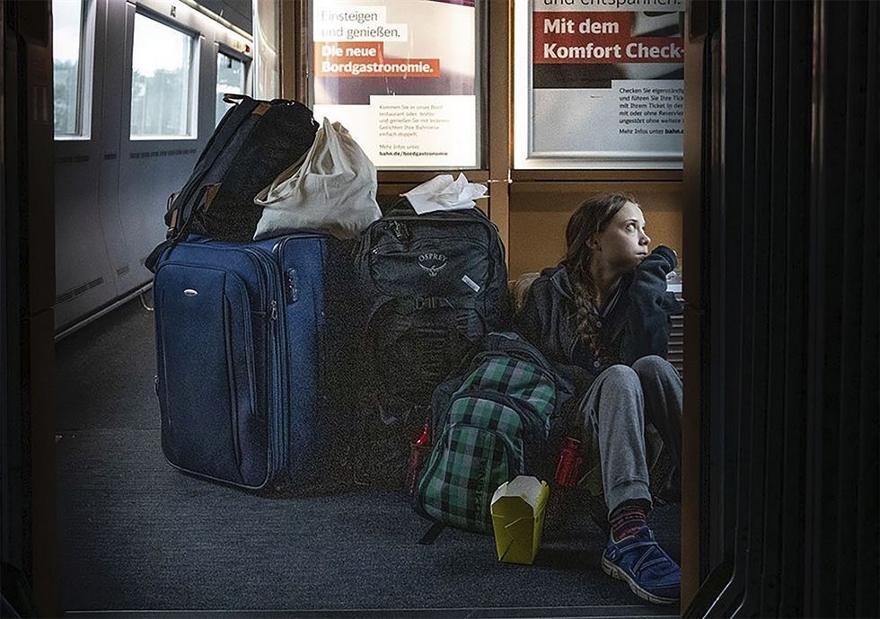 Activist Greta Thunberg sits on floor on homeward-bound German train