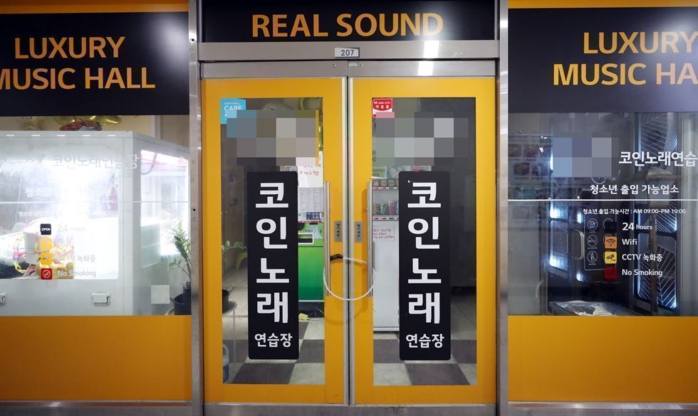 A coin noraebang booth with karaoke screens and microphones in Incheon