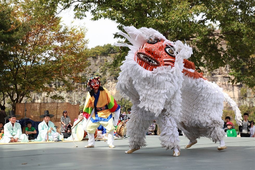 Performers in Bongsan Talchum Korean mask dance drama wearing traditional masks and colorful robes