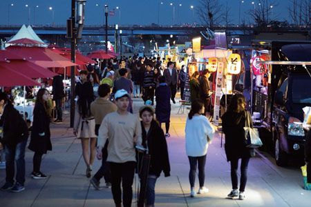 Seoul Bamdokkaebi Night Market goblin night market food trucks along the Han River at Yeouido Hangang Park at dusk