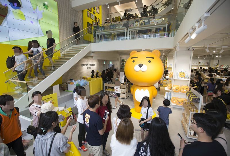 Citizens pose for photos with a giant Ryan figure at the Kakao Friends flagship store near Gangnam Station in southern Seoul on its opening weekend