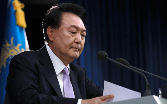 Impeached president resists arrest over martial law bid