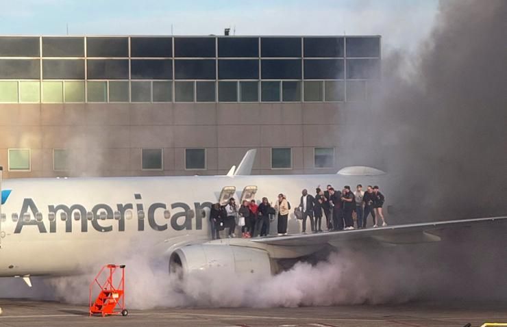 Aircraft catches fire after landing in Denver, sending passengers onto wing as smoke engulfs plane